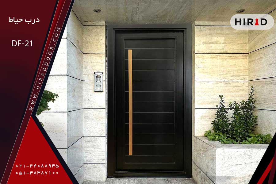 درب فلزی حیاط تک لنگه مشکی رنگ، یکپارچه، با دستگیره عمودی بلند به رنگ مسی، نصب شده در ورودی ساختمان جنوبی